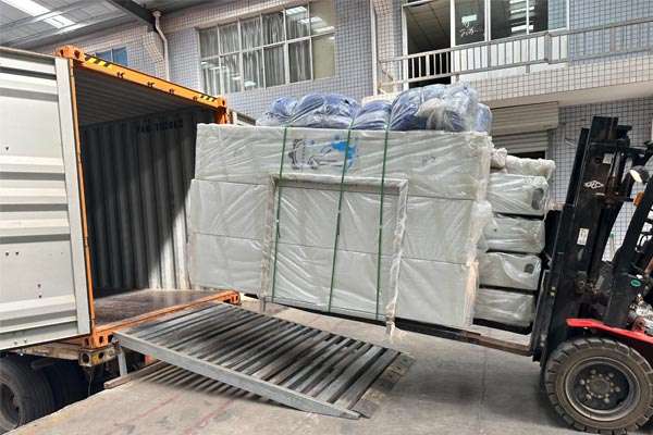 Forklift loading wrapped car wash machine parts into a container