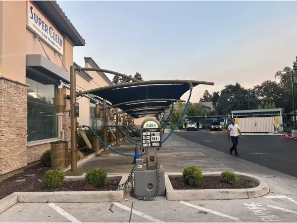 Central vacuum station with hoses under a canopy at a car wash