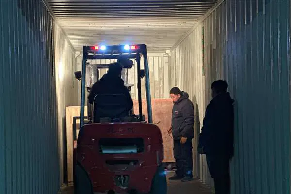 Forklift loading the US K3 touchless car wash machine into a container